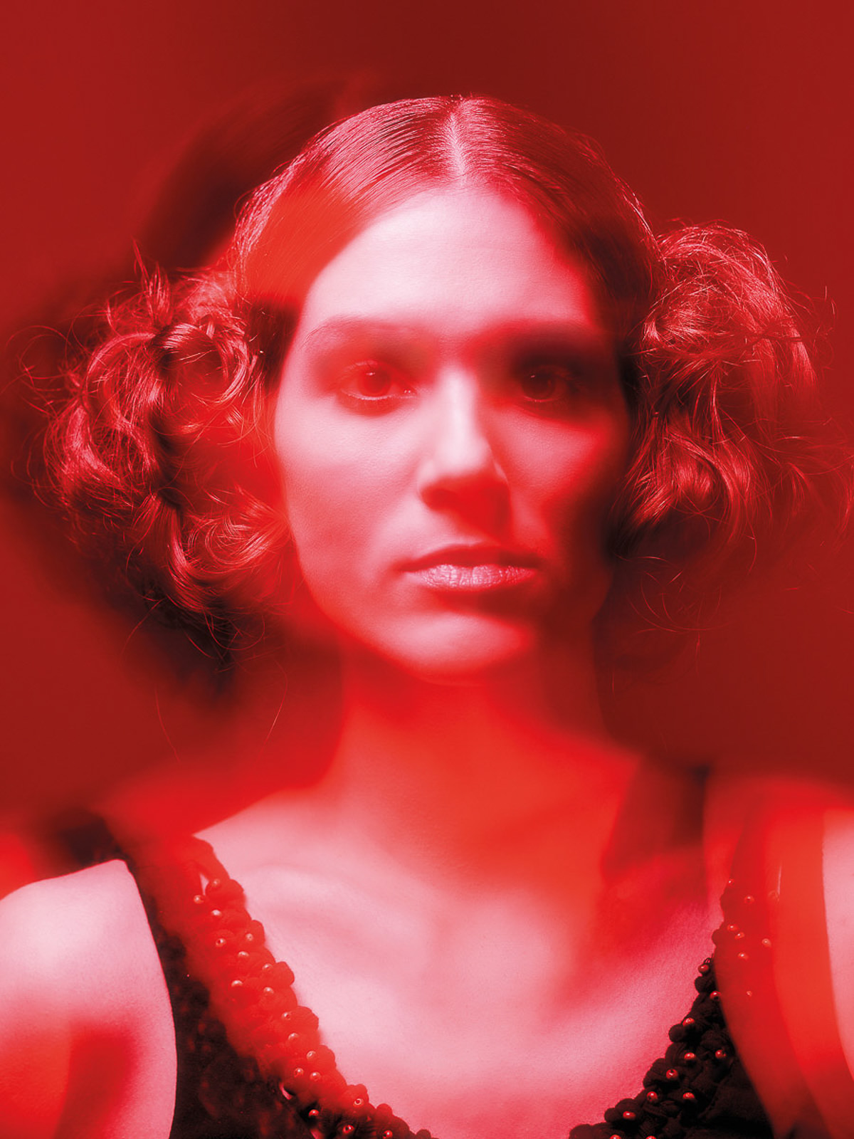 Künstlerisches Porträt einer Frau mit roter Lichtüberlagerung, surrealer Effekt. Intensiver Blick, kreative Fotografie.