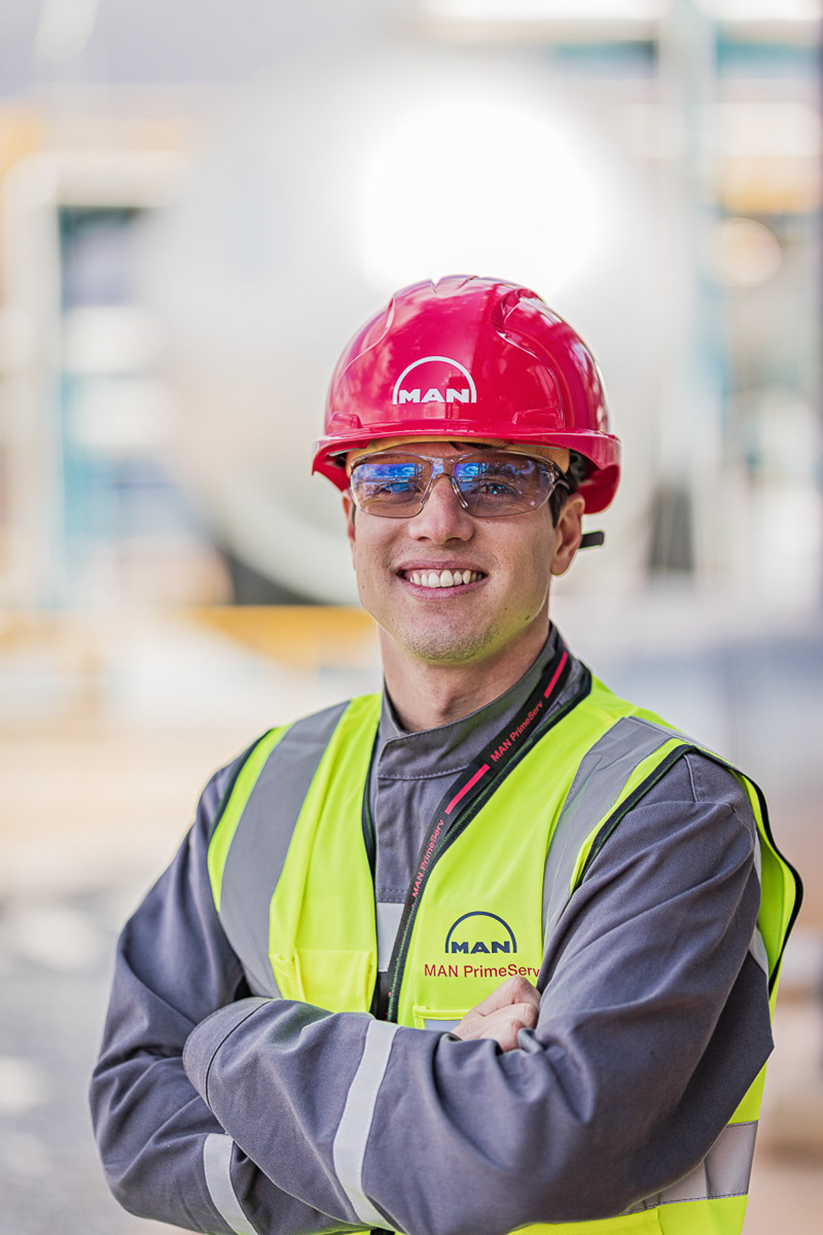 Ein Mann trägt einen Schutzhelm und eine Sicherheitsweste, bereit für die Arbeit auf einer Baustelle.