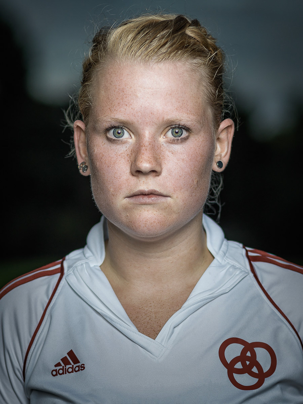 Porträt einer jungen Sportlerin vor dunklen Hintergrund.