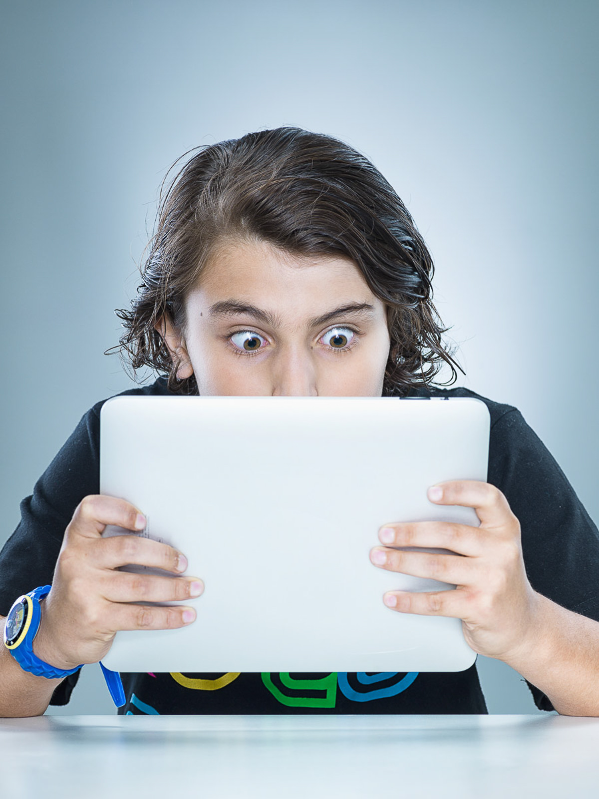Ein Junge schaut fasziniert auf ein Tablet und entdeckt die Welt der digitalen Inhalte.  