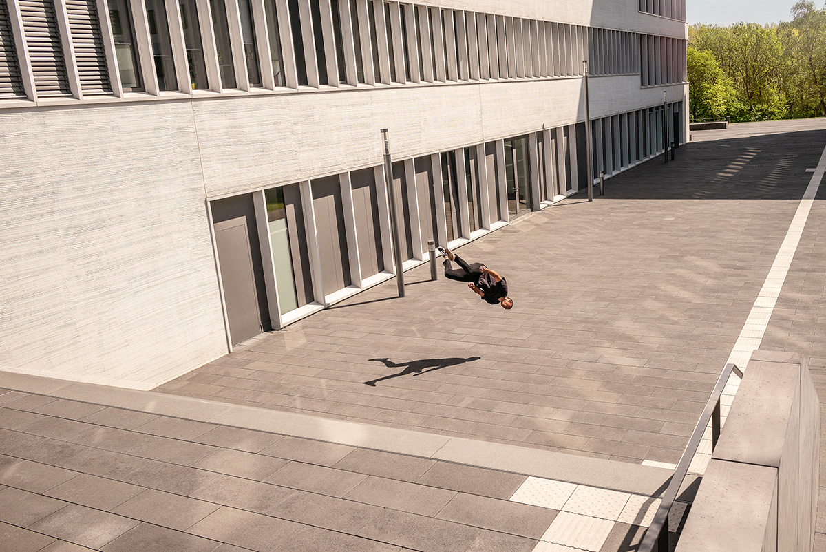 Free Running Artist beim Jump vor modernen Bürogebäude.